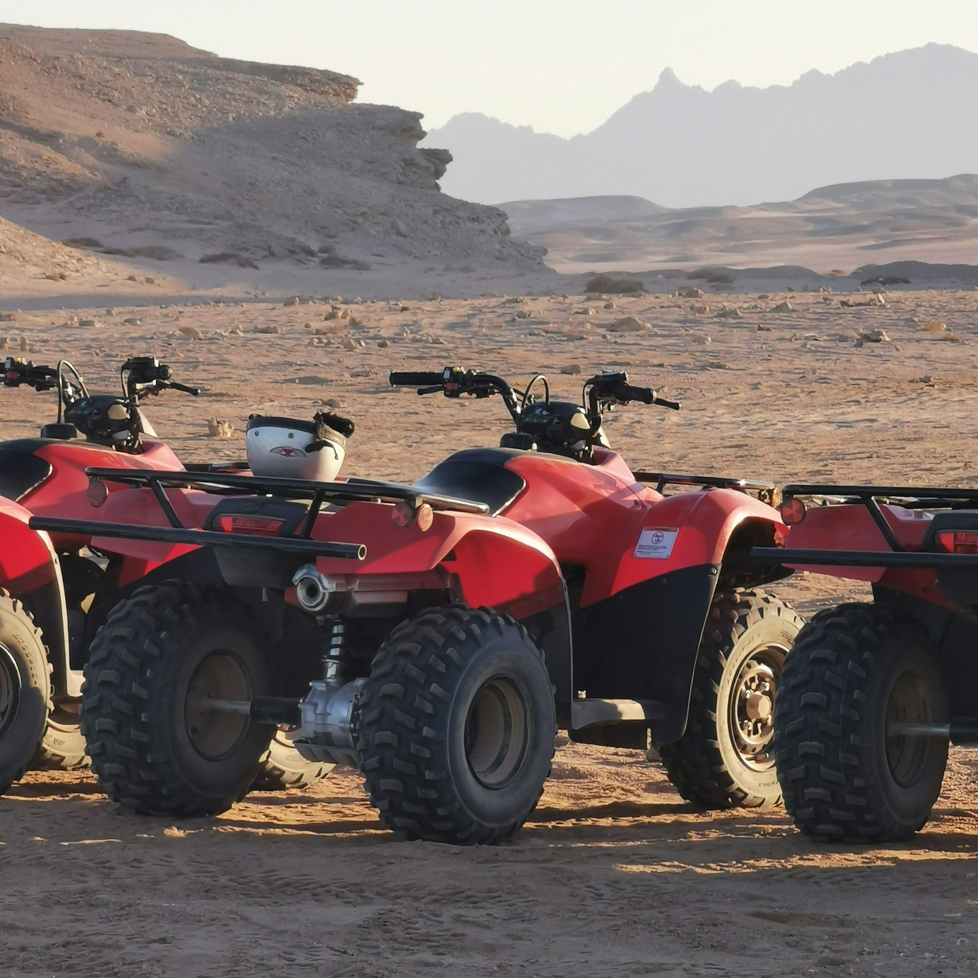 red and black atv on brown sand